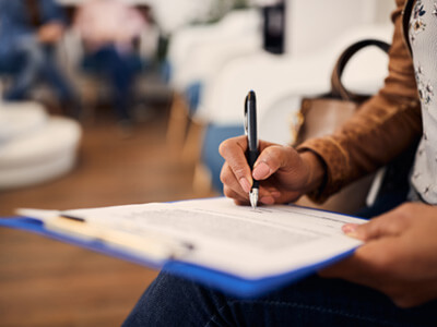 Woman filling out dental insurance form in lobby